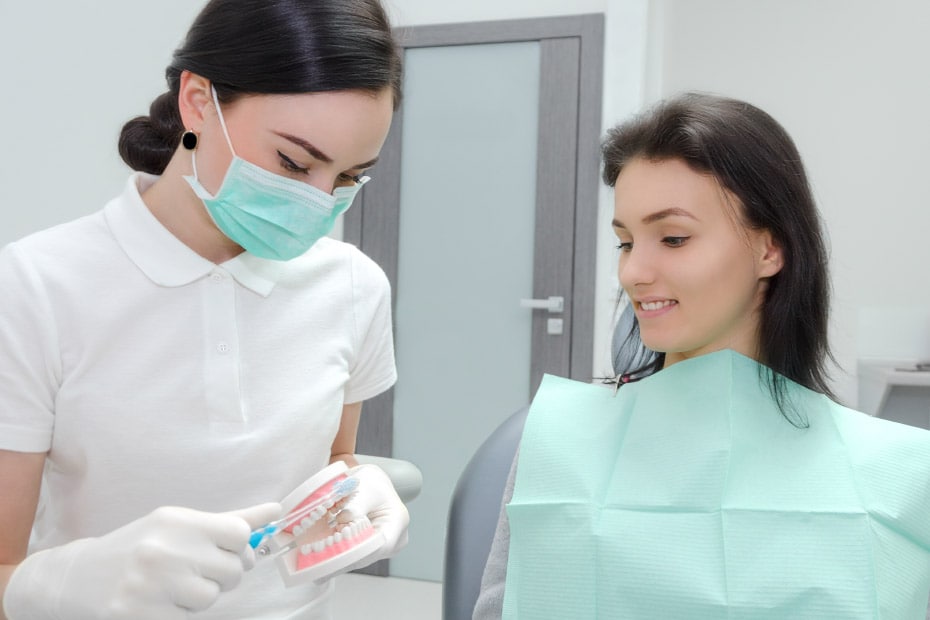dentista-enseña-como-cepillar-dientes-con-dentadura
