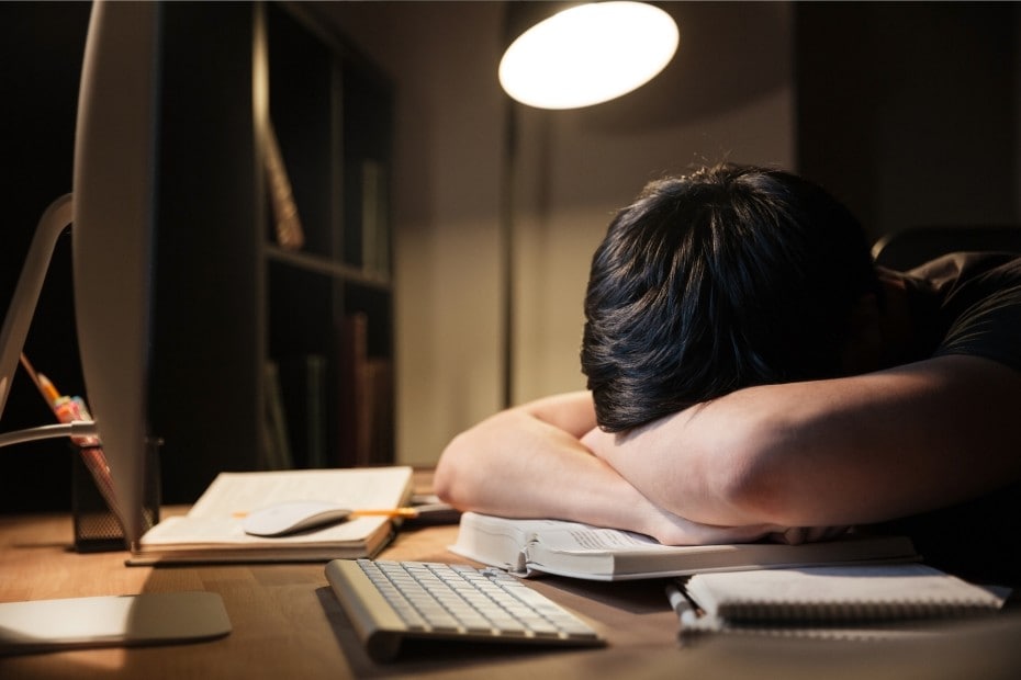 joven-exhausto-sobrepasado-de-estudiar-durmiendo