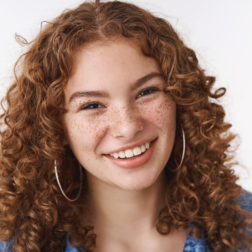 estudiante-femenina-joven-sonriendo-despreocupada-de-cerca