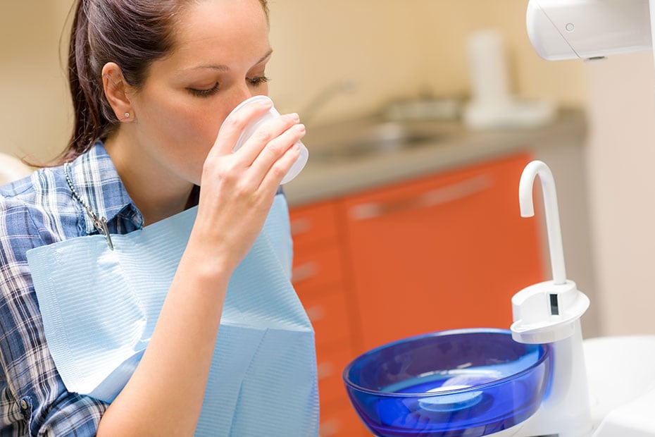 dentista-paciente-dental-mujer-enjuague-bucal