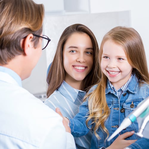 Madre e hija hablan con su profesional de la salud dental