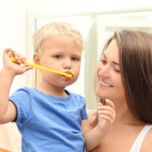 madre enseña a hijo cómo cepillarse